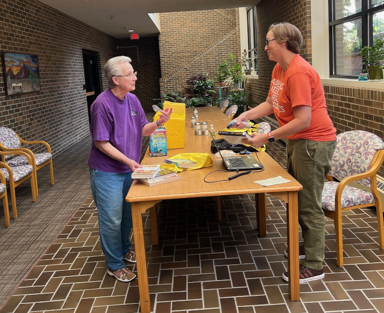 Library staff member talking with someone at a senior living community.