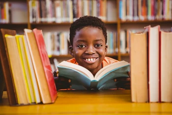 Smiling child with a book.